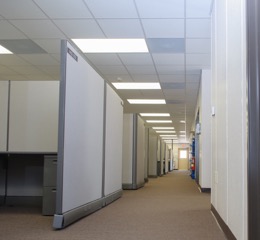 Interior of a modular building, showing a hallway of cubicles offices.