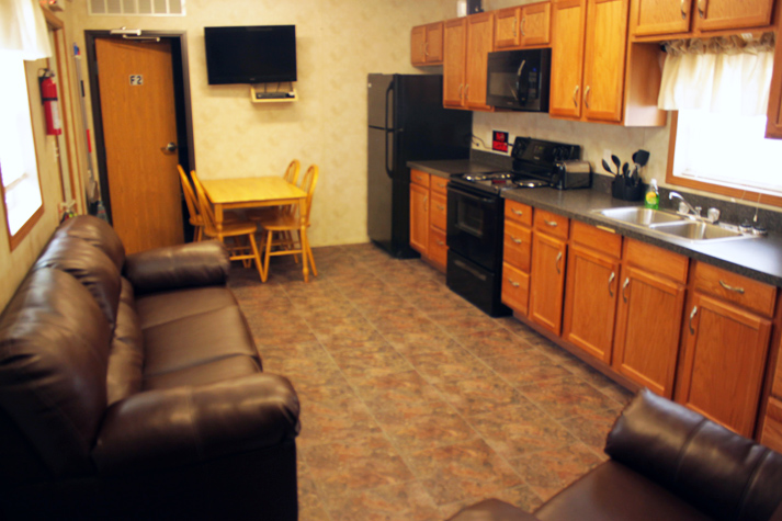 A picture of an interior of one of Aries' mobile remote lodging, featuring comfortable couches and kitchenette.