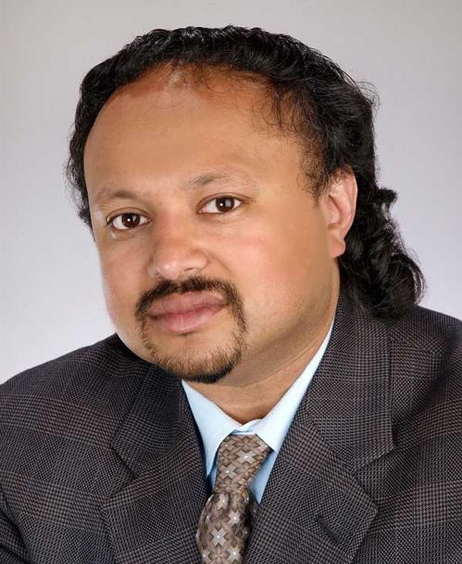 A photograph of Aries’ sponsored, keynote speaker Anirban Basu – a kind looking dark-haired man with a goatee and sparkly bright brown eyes.