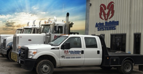 Aries’ trucks parked outside the Aries’ modular building manufacturing facility in Troy, Texas at sunset.