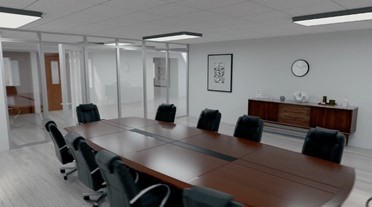 Photo of the interior of a modular building that has been converted into office space with a fully furnished conference room with a wood conference table, chairs, and a glass partition wall separating the room from the rest of the building.