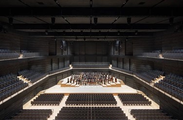 Interior shot of modular concert hall with aisles and rows and tiers of seats in the balconies. Credit HGEsch/gmp Architekten