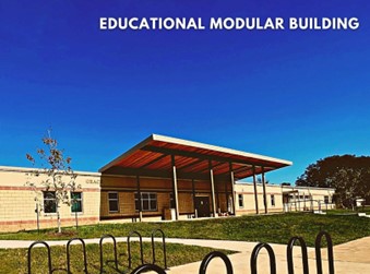 A photograph of a modular educational building under a blue sky. In front there is green grass lined with sidewalks and bike racks. The phrase, “EDUCATIONAL MODULAR BUILDING” is on the upper right of the photo.