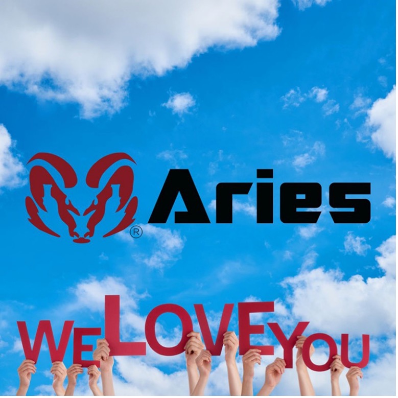 Group of hands holding red letter cut-outs that spell “We Love You” on the sky and the red ram logo of Aries is in the center of the blue sky with a few clouds.