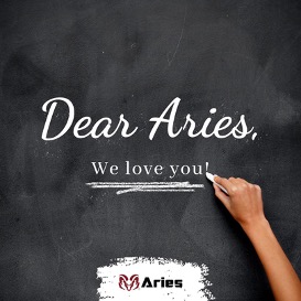 A VisionAries writing “Dear Aries, We love you!” on a black chalkboard. On the bottom of the chalboard is a highlighted red ram logo of the leading modular building provider, Aries.