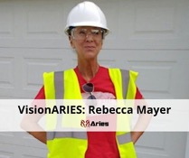 VisionAries, Rebecca Mayer, smiling confidently while wearing a hard hat and a neon safety vest. At the bottom is a white banner that reads, “VisionAries: Rebecca Mayer” and the red ram logo of Aries directly under it.