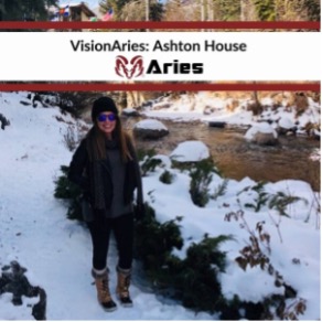 VisionAries, Ashton House, smiling and standing amid snow and rocks next to a river. At the top is a white banner with a thick red border that reads, “VisionAries: Ashton House” and the red ram Aries’ logo under it.