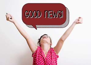 A person wearing a red sleeveless polka dot shirt and putting their arms up as if they are relieved and triumphant and a red and black conversation bubble graphic above them that reads, “GOOD NEWS!”