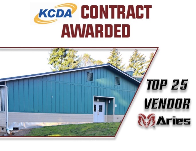 Contract achievement recognition: Aries, a Top 25 Vendor, awarded KCDA contract for modular building excellence. Image is a large blue modular building.
