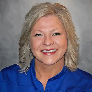 Traci Prater Sales Associate for Aries Buildings headshot of smiling blonde woman with blue collared shirt.