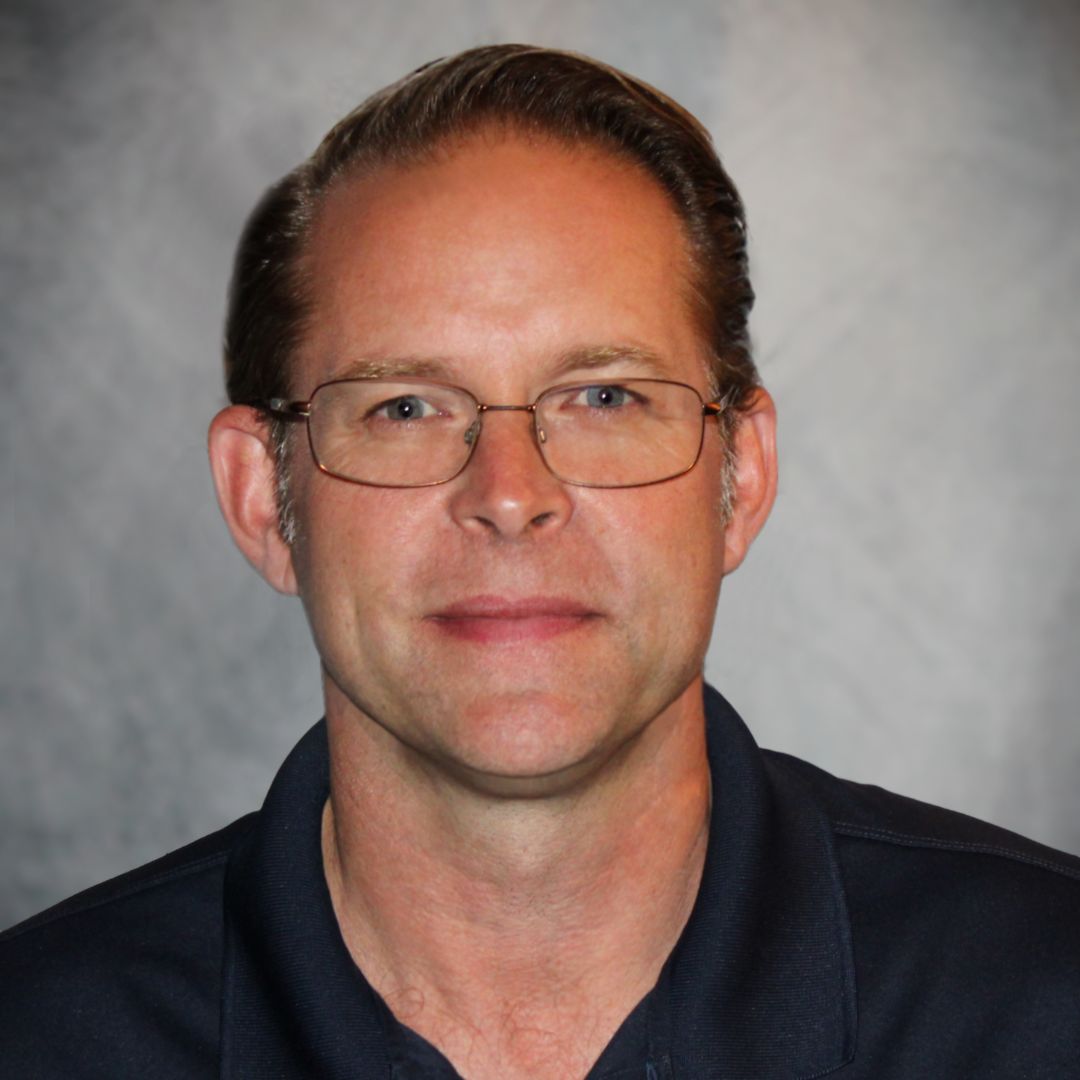 Headshot of David Jones, Territory Sales Manager for Aries Buildings. He is wearing glasses and a black collared shirt.