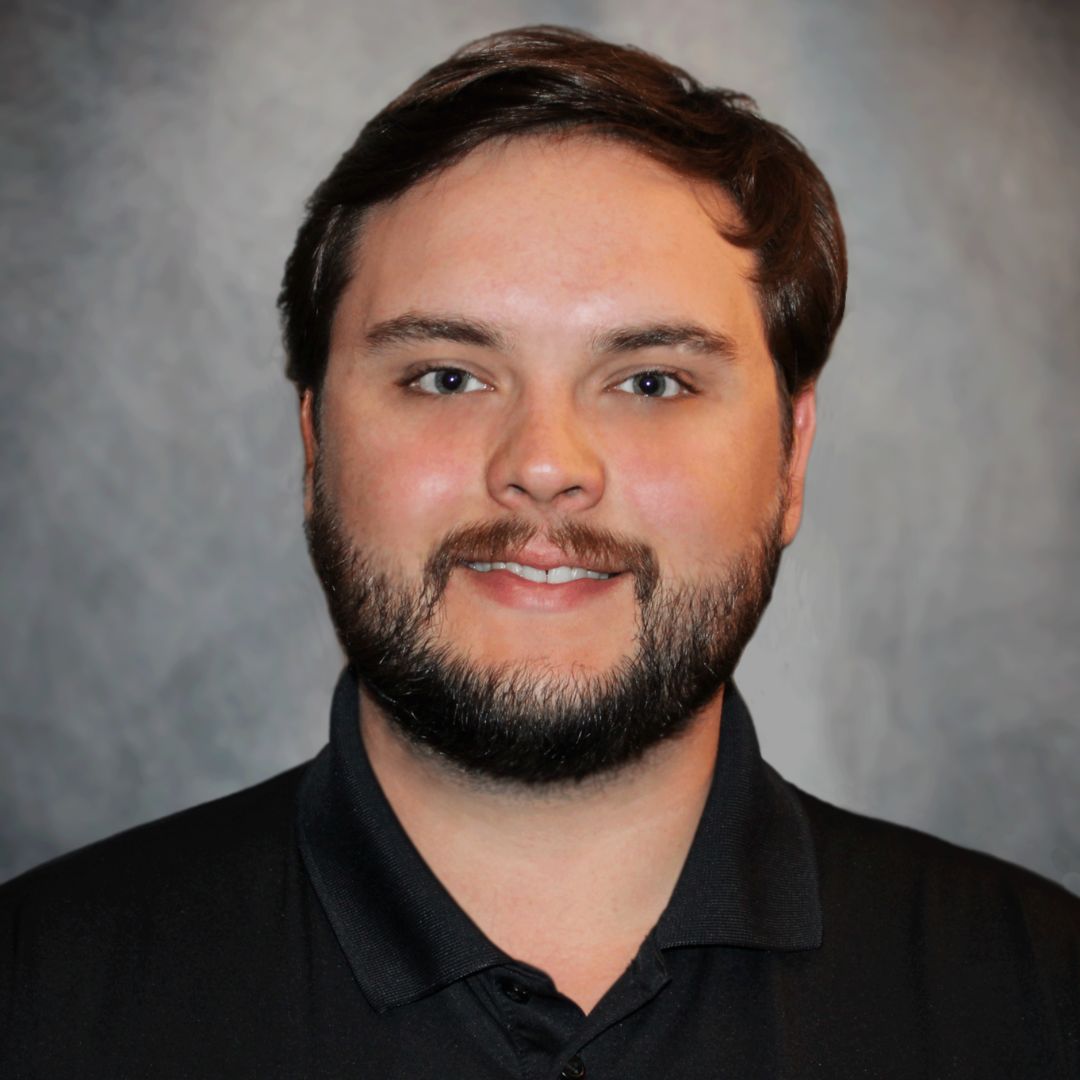 Headshot of Kurtis Kolanek, Aries' Sales Associate in Pasadena, TX. He has brown hair and is wearing a black collared shirt.