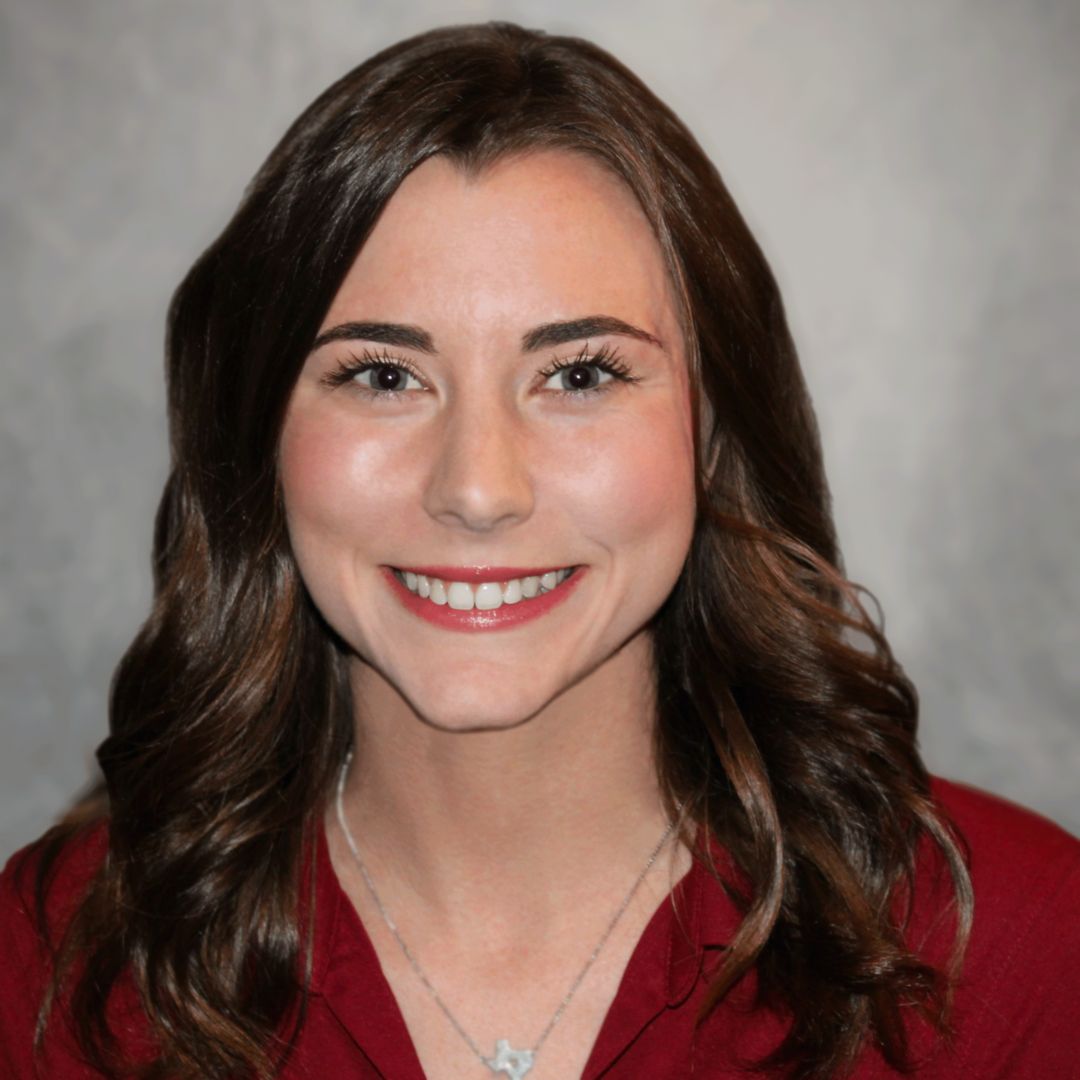 Headshot of Tori Grier, Sales Associate for Aries Buildings. She is wearing a maroon shirt and has short brown hair.