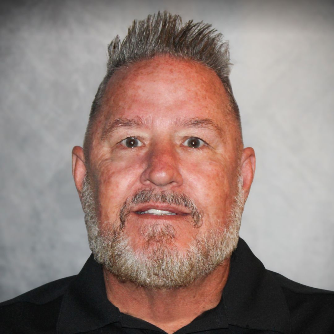 Headshot of Ash Mote, Sales Associate in Gibsonton, FL for Aries Buildings. He has spiked hair, a beard, and is wearing a black collared shirt.