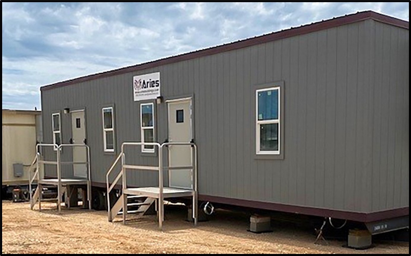 Modular building with a metal ramp, on a sunny day.