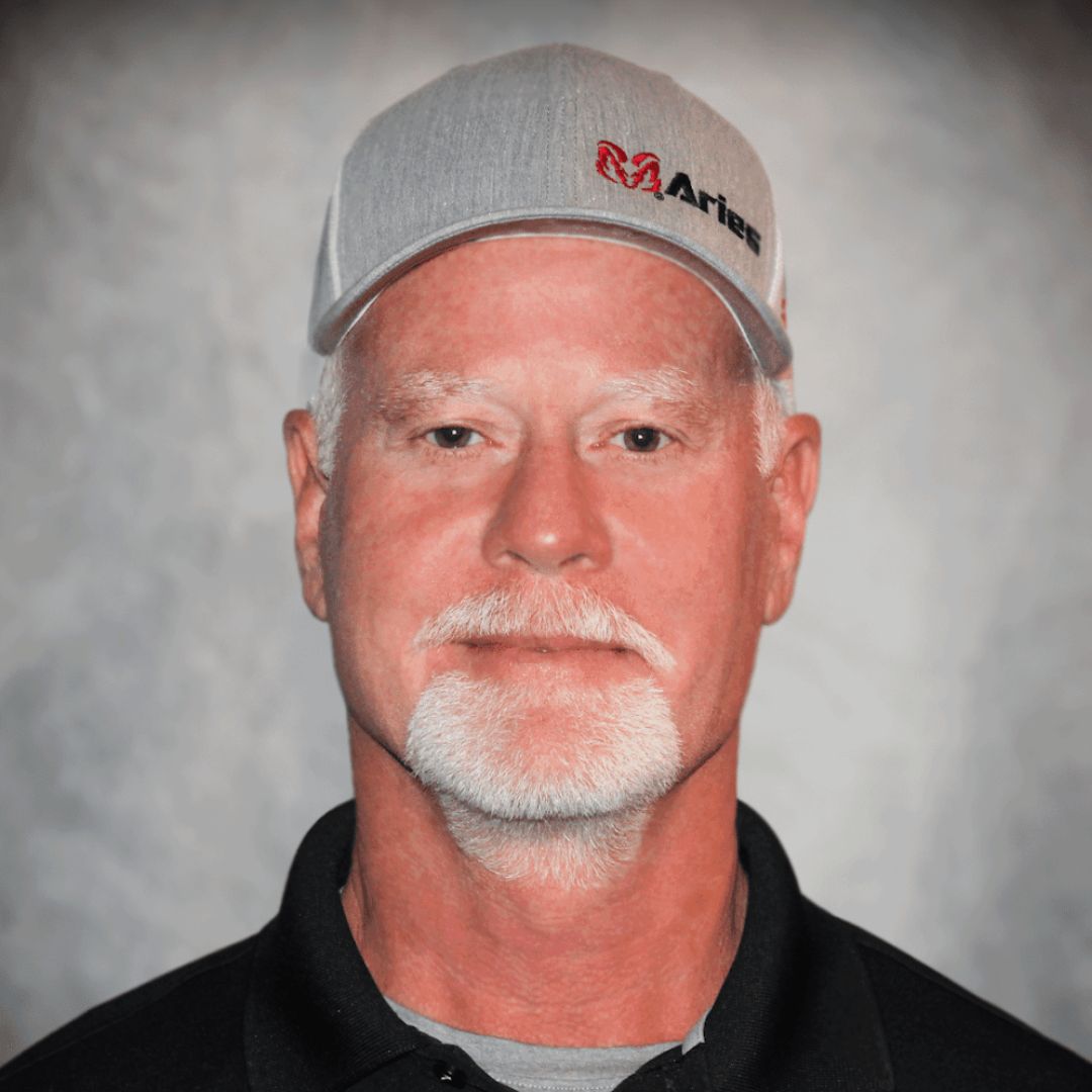 Headshot of Bryan Wilkerson, Territory Sales Manager in Cleburne, TX for Aries Buildings. He is wearing an Aries ball cap and a black collared shirt.