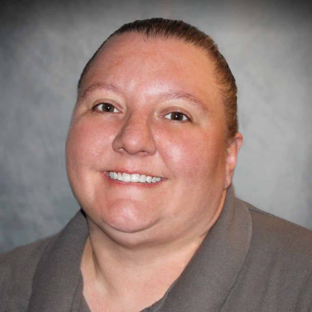 Headshot of Heather Irwin, Sales associate for Aries Buildings in Rochester, IN. She has her hair pulled back and is wearing a gray collared shirt.