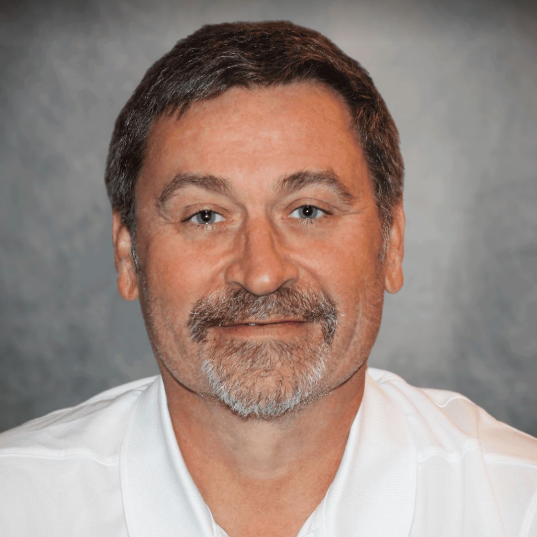 Headshot of Lonn Ellzey, Sales Associate for Aries Buildings in LaPlace, LA. He has short brown hair, facial hair, and is wearing a white collared shirt.