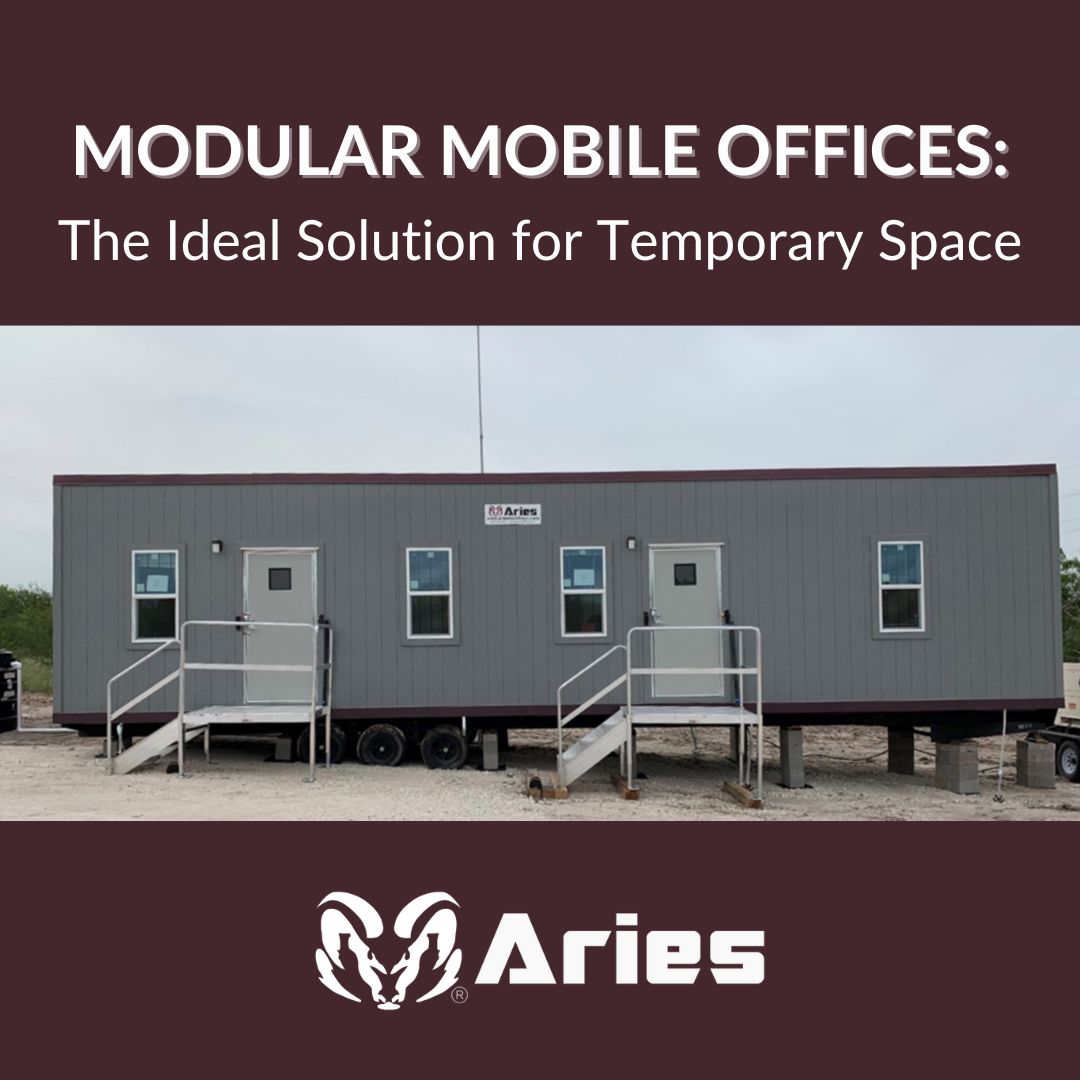 A long, grey trailer office, two doors and four windows, has two sets of metal stairs leading to the doors and sits connected to a supply of water, a long antenna on top, and an electric generator, all on a sandlot.