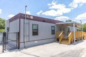 Exterior view of a portable classroom with ADA-accessible ramp and metal siding, providing flexible modular school space.