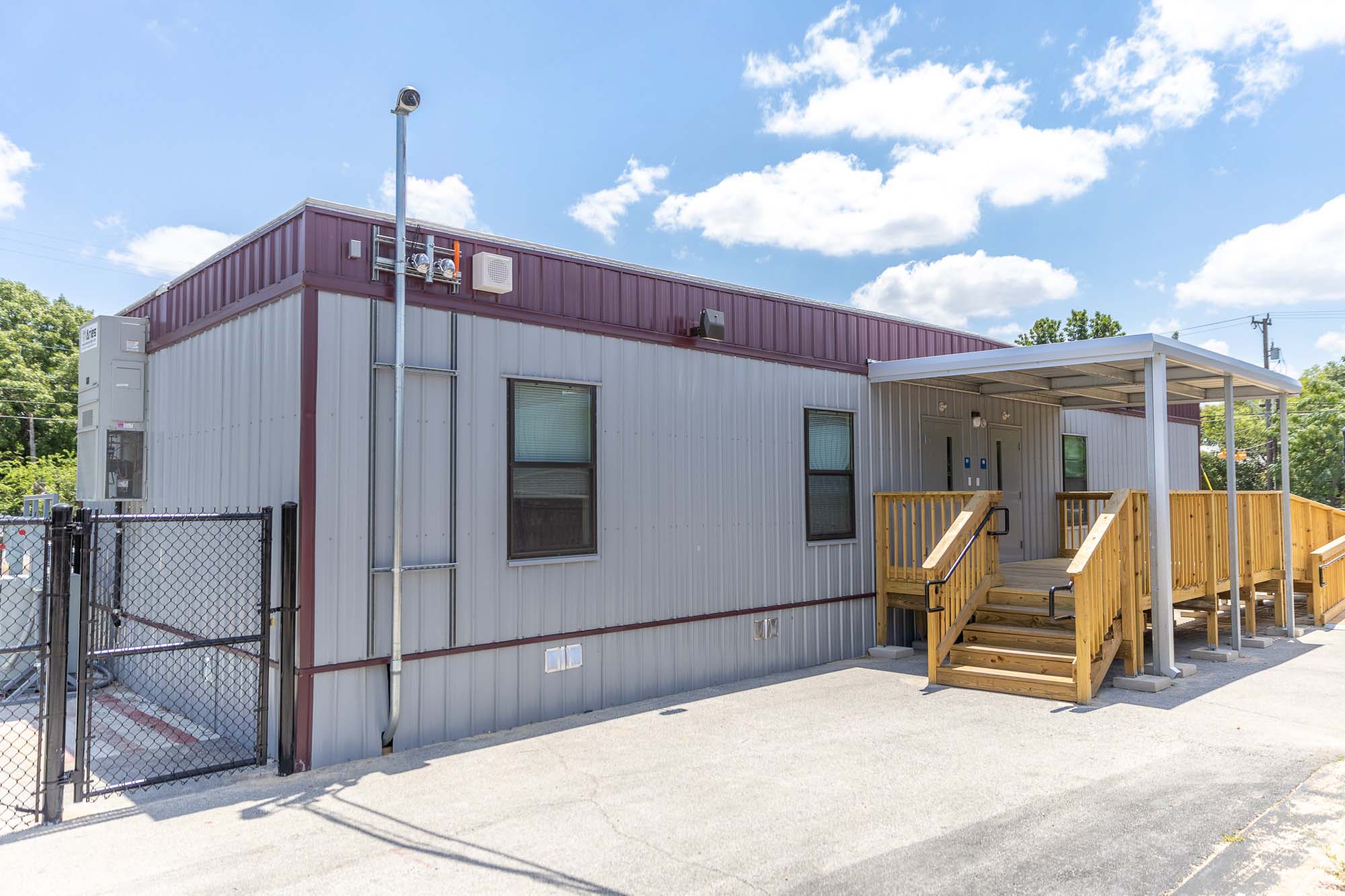 Exterior view of a portable classroom with ADA-accessible ramp and metal siding, providing flexible modular school space.