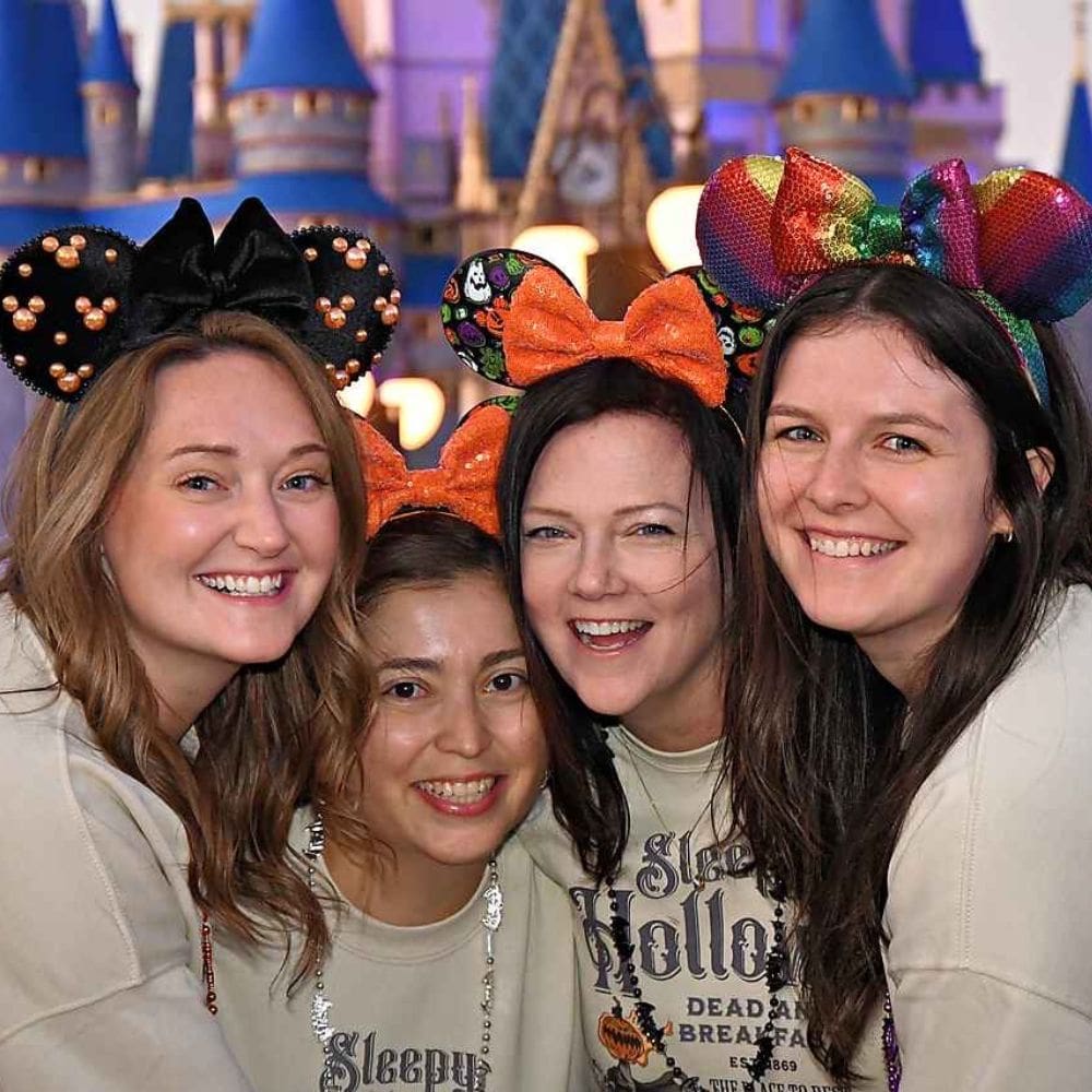 A photo of VisionAries Spotlight, Bailey Beck, smiling with friends at Disney World wearing Mickey Mouse ears.