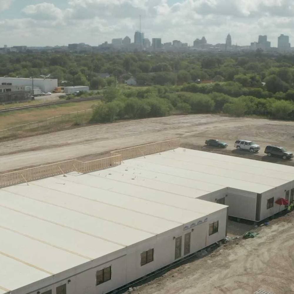 Overview of Aries’ modular construction with city in the distance.